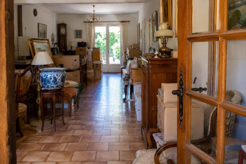 Séjour encombré d'un logement de succession, allée dégagée jusqu'à la fenêtre